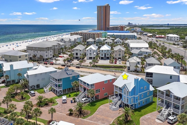 drone / aerial view featuring a beach view and a water view