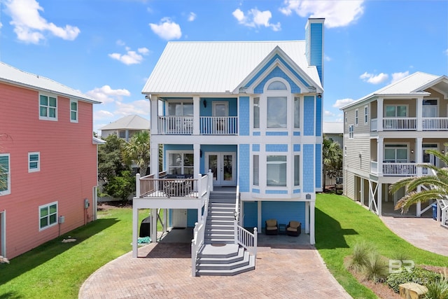 back of property featuring stairs, a yard, french doors, and a chimney