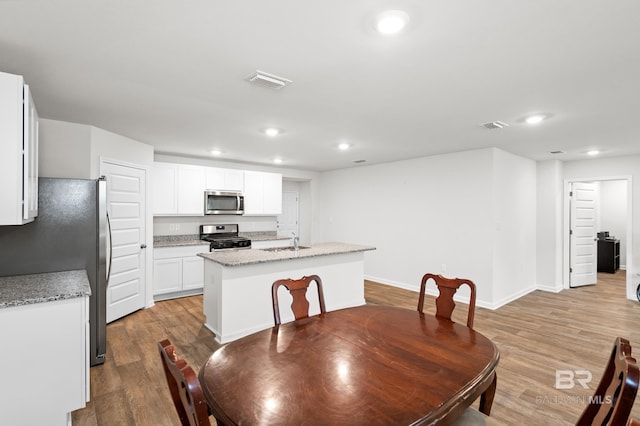 dining space with light hardwood / wood-style flooring and sink