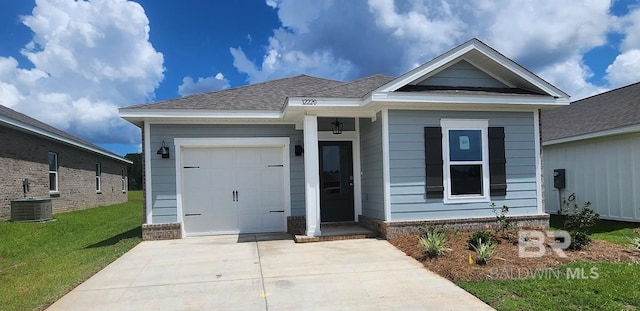 view of front of property featuring a garage, central air condition unit, and a front yard