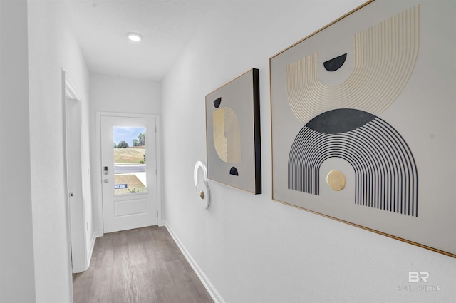 corridor with hardwood / wood-style flooring