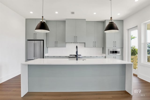 kitchen with decorative backsplash, light countertops, high end refrigerator, and gray cabinets