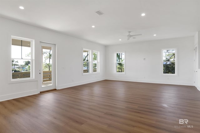 unfurnished living room featuring recessed lighting, dark wood finished floors, a wealth of natural light, and ceiling fan