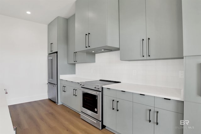kitchen featuring stainless steel appliances, light countertops, baseboards, and gray cabinets