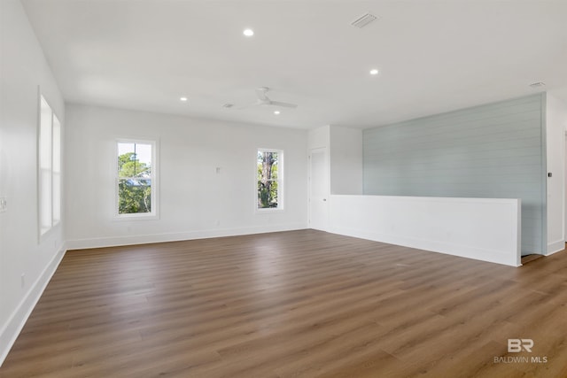 spare room featuring baseboards, wood finished floors, and recessed lighting