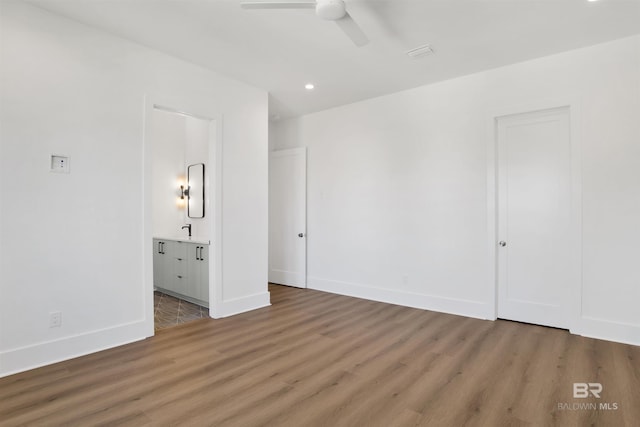 unfurnished bedroom with a ceiling fan, wood finished floors, baseboards, ensuite bath, and recessed lighting