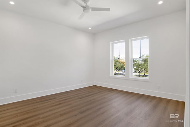 spare room featuring recessed lighting, dark wood-type flooring, a ceiling fan, and baseboards