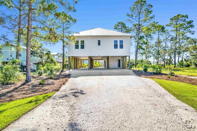 view of front of house with gravel driveway, a carport, and metal roof