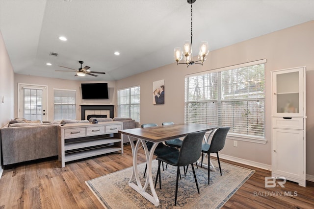 dining space with visible vents, wood finished floors, recessed lighting, baseboards, and a tile fireplace