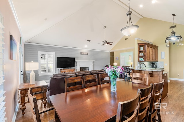 dining area with lofted ceiling, ceiling fan, sink, and hardwood / wood-style floors