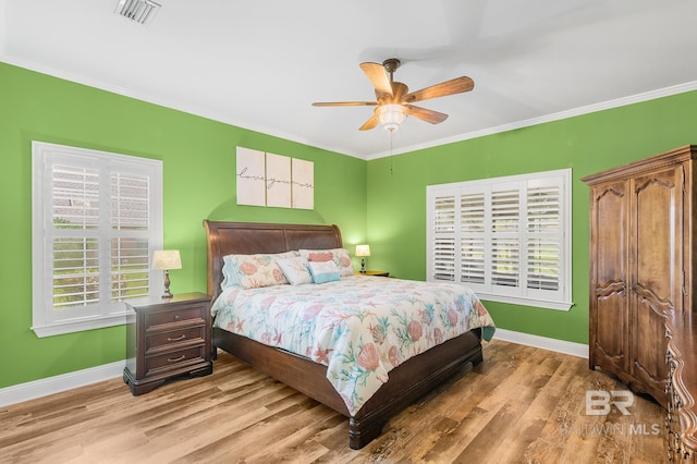 bedroom with ceiling fan, light hardwood / wood-style floors, and crown molding