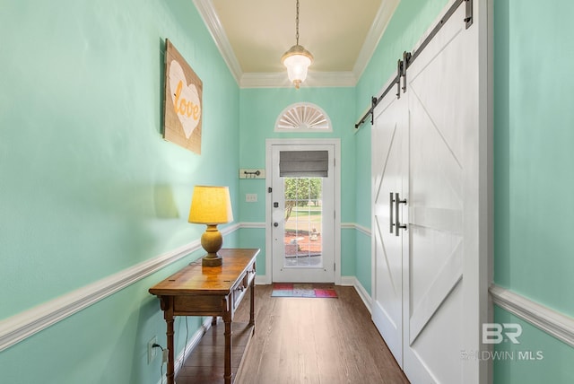 doorway to outside featuring a barn door, dark hardwood / wood-style floors, and crown molding