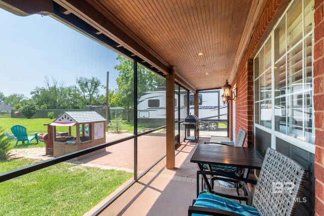 sunroom with plenty of natural light and wooden ceiling