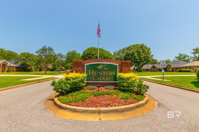 community / neighborhood sign featuring a yard