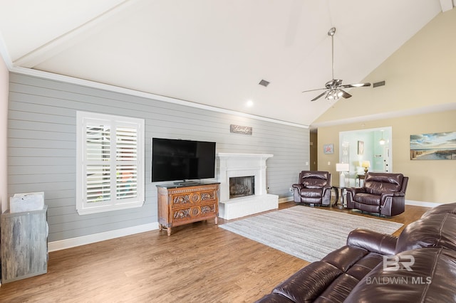 living room with ceiling fan, hardwood / wood-style floors, and wooden walls