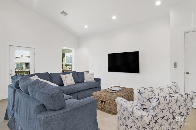 living room featuring vaulted ceiling, visible vents, and recessed lighting