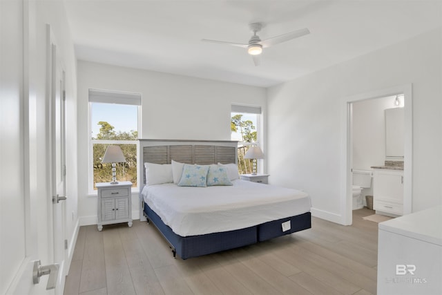 bedroom with light wood-style floors, multiple windows, and baseboards