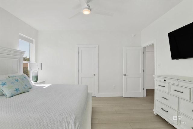 bedroom with light wood-style floors, baseboards, and a ceiling fan