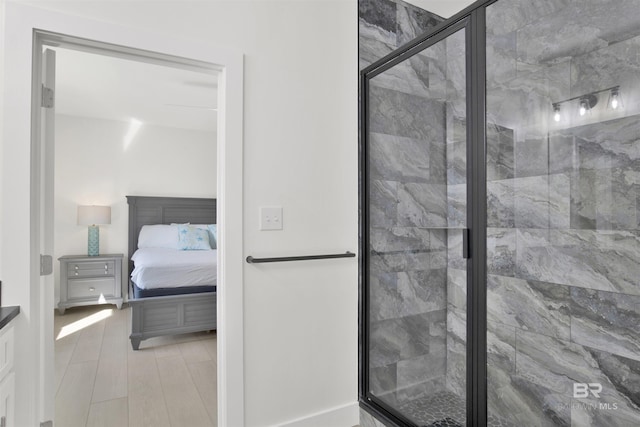 bathroom featuring a stall shower, connected bathroom, and wood finished floors