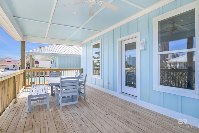 wooden terrace with ceiling fan and outdoor dining area