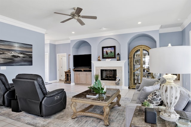 living area featuring ornamental molding, a glass covered fireplace, ceiling fan, and light tile patterned floors