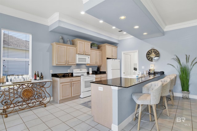 kitchen featuring white appliances, a kitchen breakfast bar, light brown cabinetry, dark countertops, and crown molding