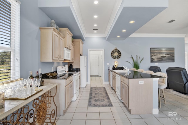 kitchen featuring white appliances, visible vents, a kitchen breakfast bar, ornamental molding, and dark countertops