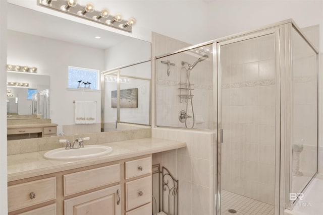 bathroom with a shower stall and vanity