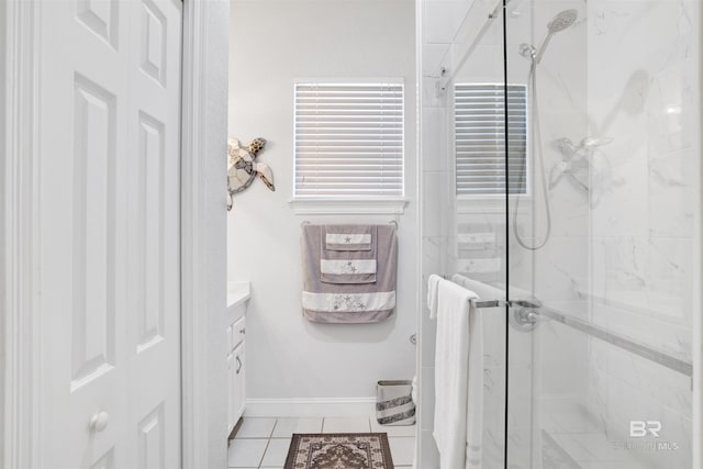 full bathroom with baseboards, vanity, a marble finish shower, and tile patterned floors