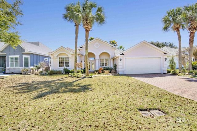 view of front of property featuring a front lawn, decorative driveway, an attached garage, and board and batten siding