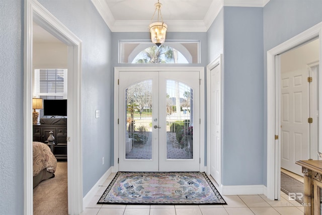 entryway with ornamental molding, french doors, light tile patterned flooring, and baseboards