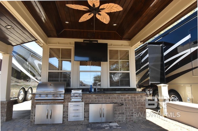 view of patio / terrace featuring area for grilling, glass enclosure, and a sink