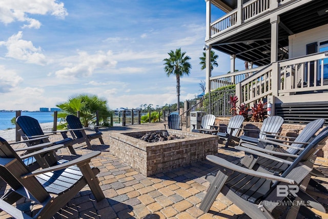 view of patio / terrace with stairway, a fire pit, and a water view