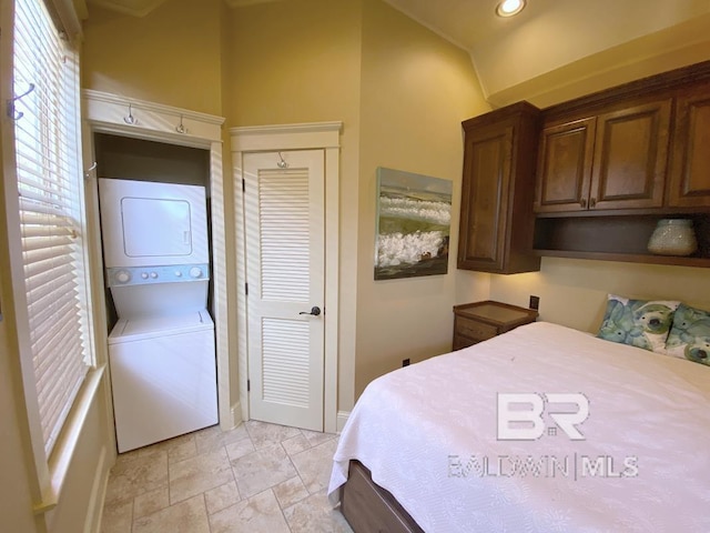 bedroom with stone finish flooring, recessed lighting, a closet, stacked washer / dryer, and vaulted ceiling
