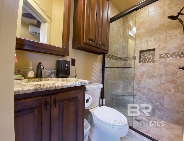 full bath with vanity, toilet, and a stall shower