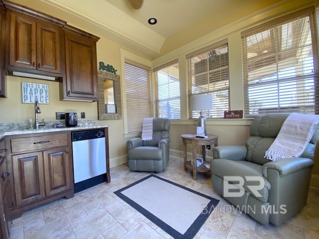 kitchen featuring vaulted ceiling, plenty of natural light, dishwasher, and a sink