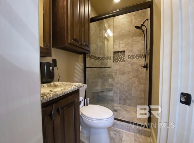 full bathroom with toilet, a stall shower, and vanity