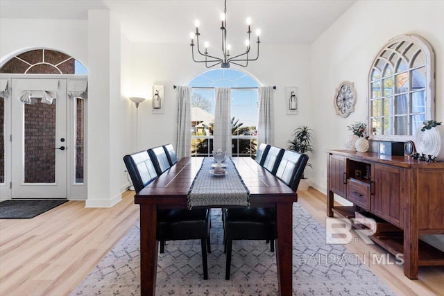 dining space with a notable chandelier and light hardwood / wood-style flooring