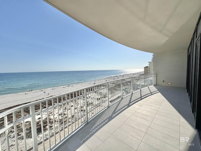 balcony featuring a view of the beach and a water view
