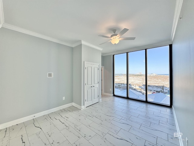 unfurnished room with baseboards, ceiling fan, expansive windows, crown molding, and marble finish floor