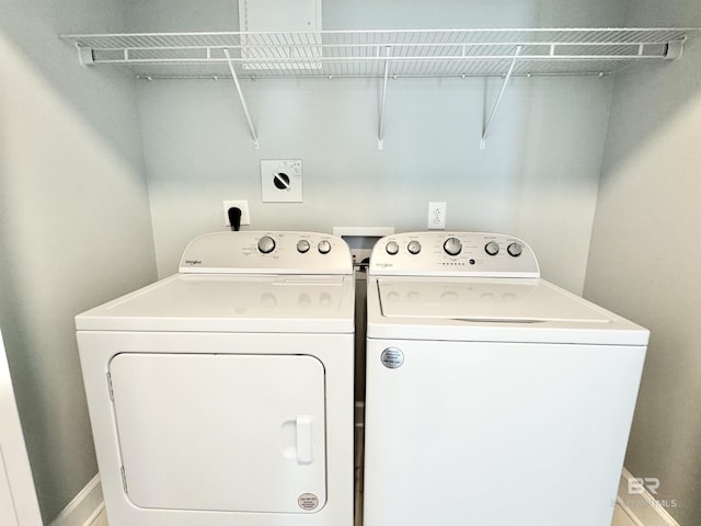 washroom with baseboards and separate washer and dryer
