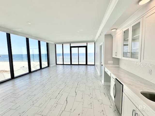 interior space with a wall of windows, baseboards, a water view, and ornamental molding
