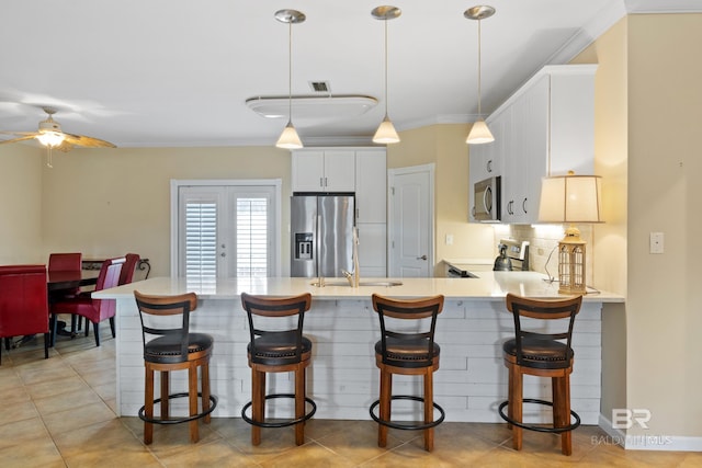 kitchen with sink, white cabinetry, backsplash, stainless steel appliances, and kitchen peninsula