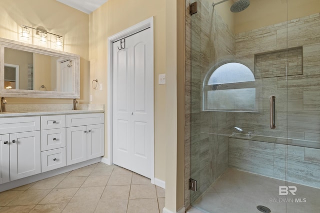 bathroom with an enclosed shower, vanity, and tile patterned floors