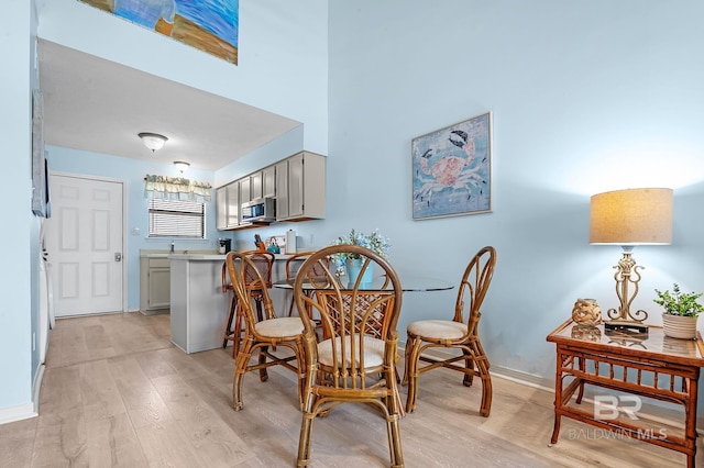 dining area with baseboards and light wood-style floors