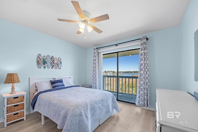 bedroom featuring light wood finished floors, a textured ceiling, a ceiling fan, and access to outside