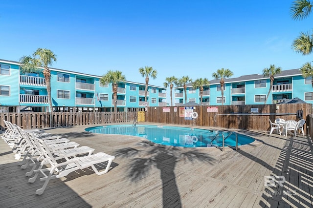 view of swimming pool featuring fence and a residential view