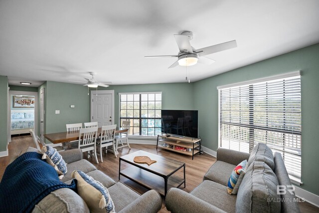 living area with ceiling fan, wood finished floors, and baseboards