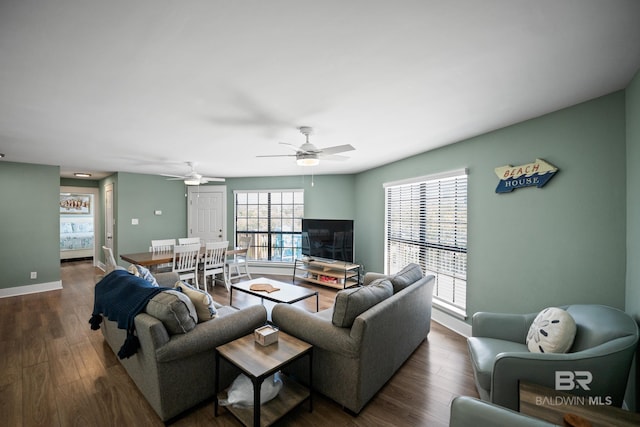 living room featuring ceiling fan, dark wood-type flooring, and baseboards