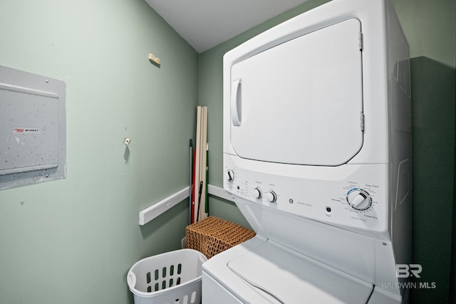 clothes washing area with stacked washer / drying machine and electric panel